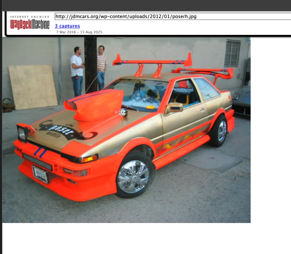 A silver car with bright orange bodywork and oversized spoilers.